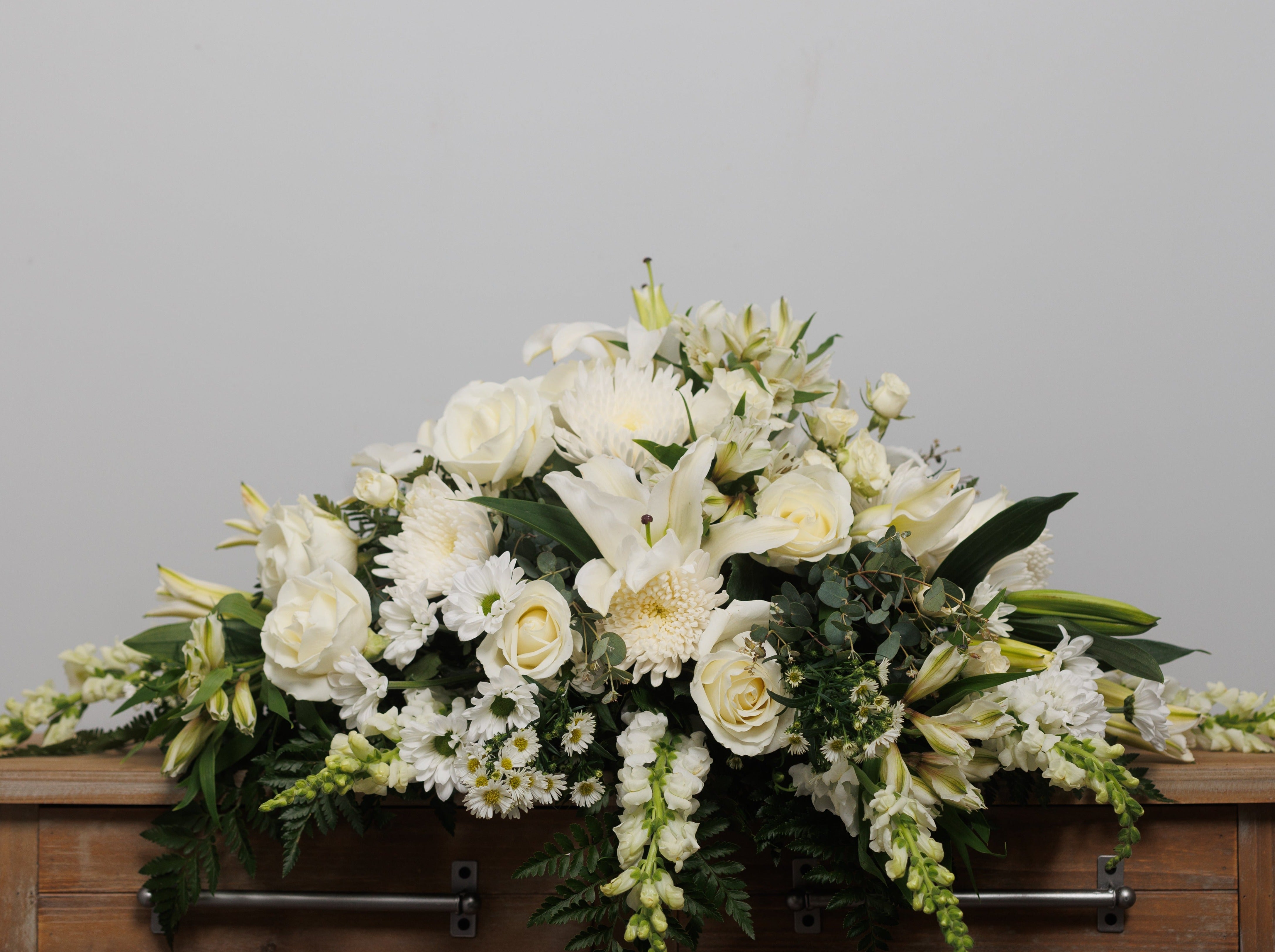 An all white casket pall.