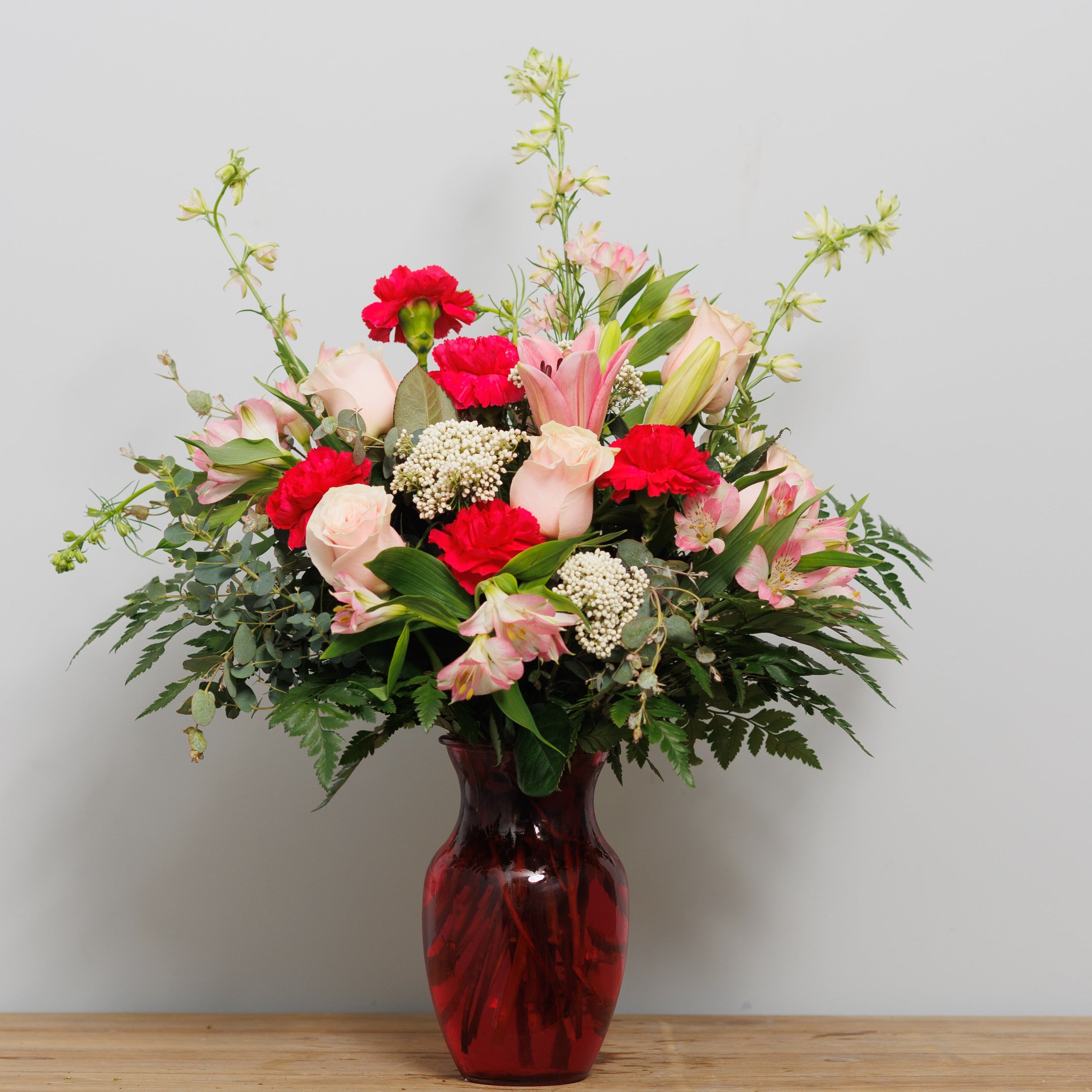 Pink and white flowers in a deep pink vase.