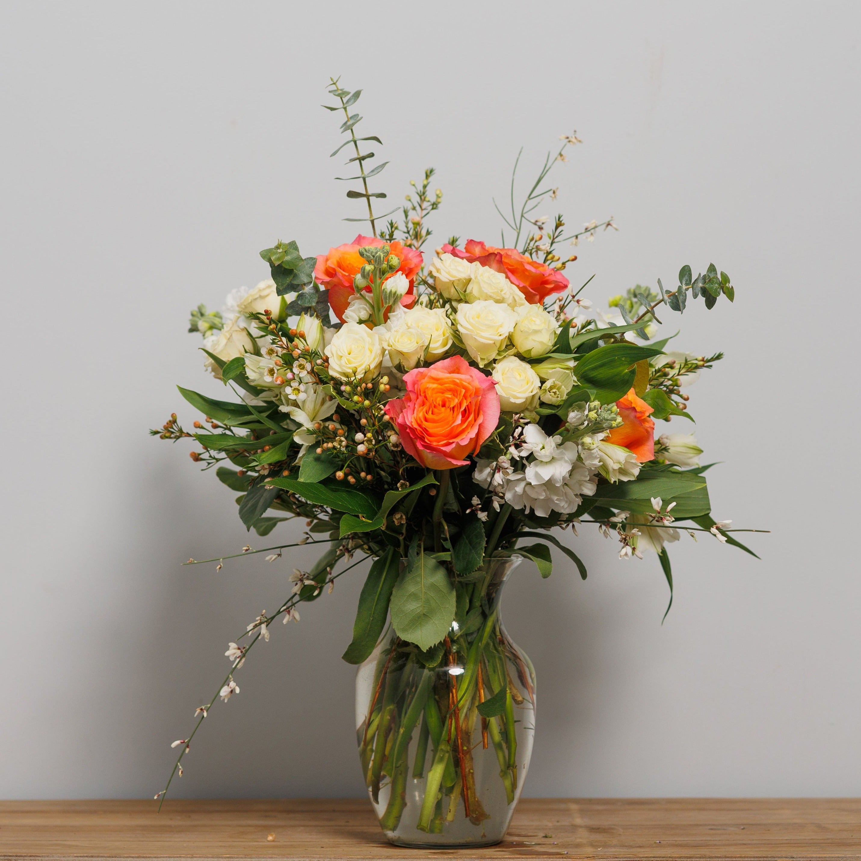 An arrangement with white spray roses, white alstroemeria and Free Spirit roses. 