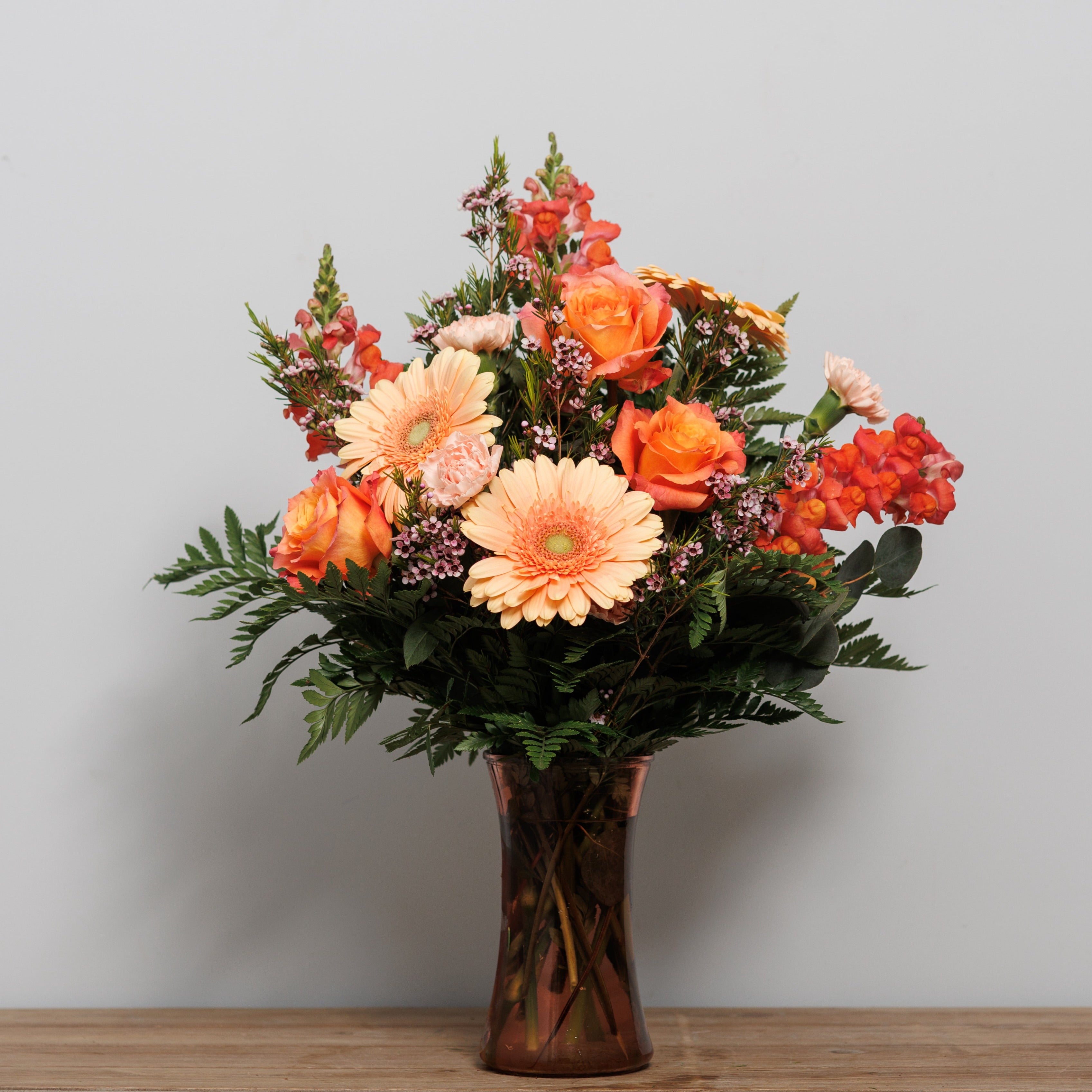 A peach and orange flower arrangement.