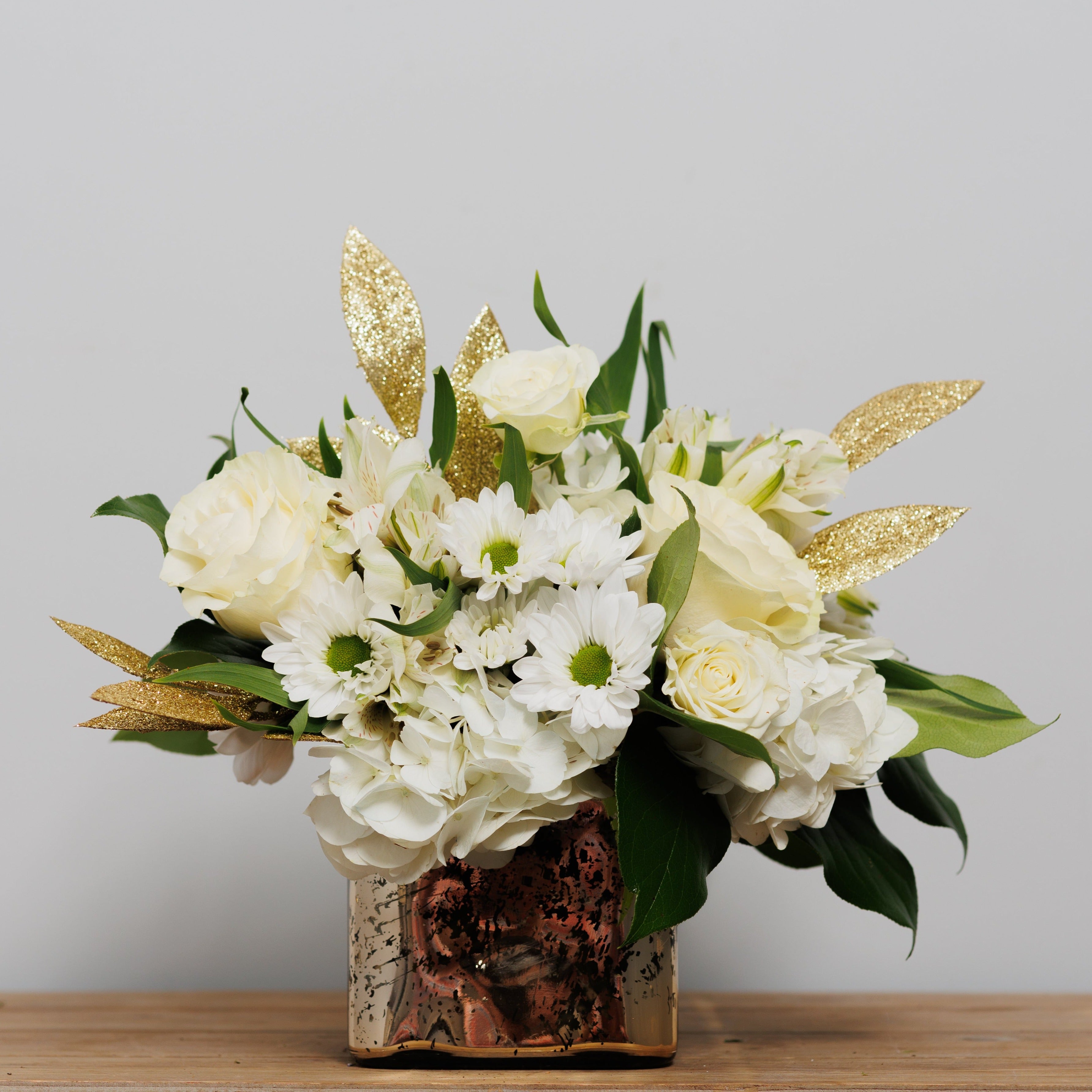 All white flowers with golden accents in a cube arrangement.