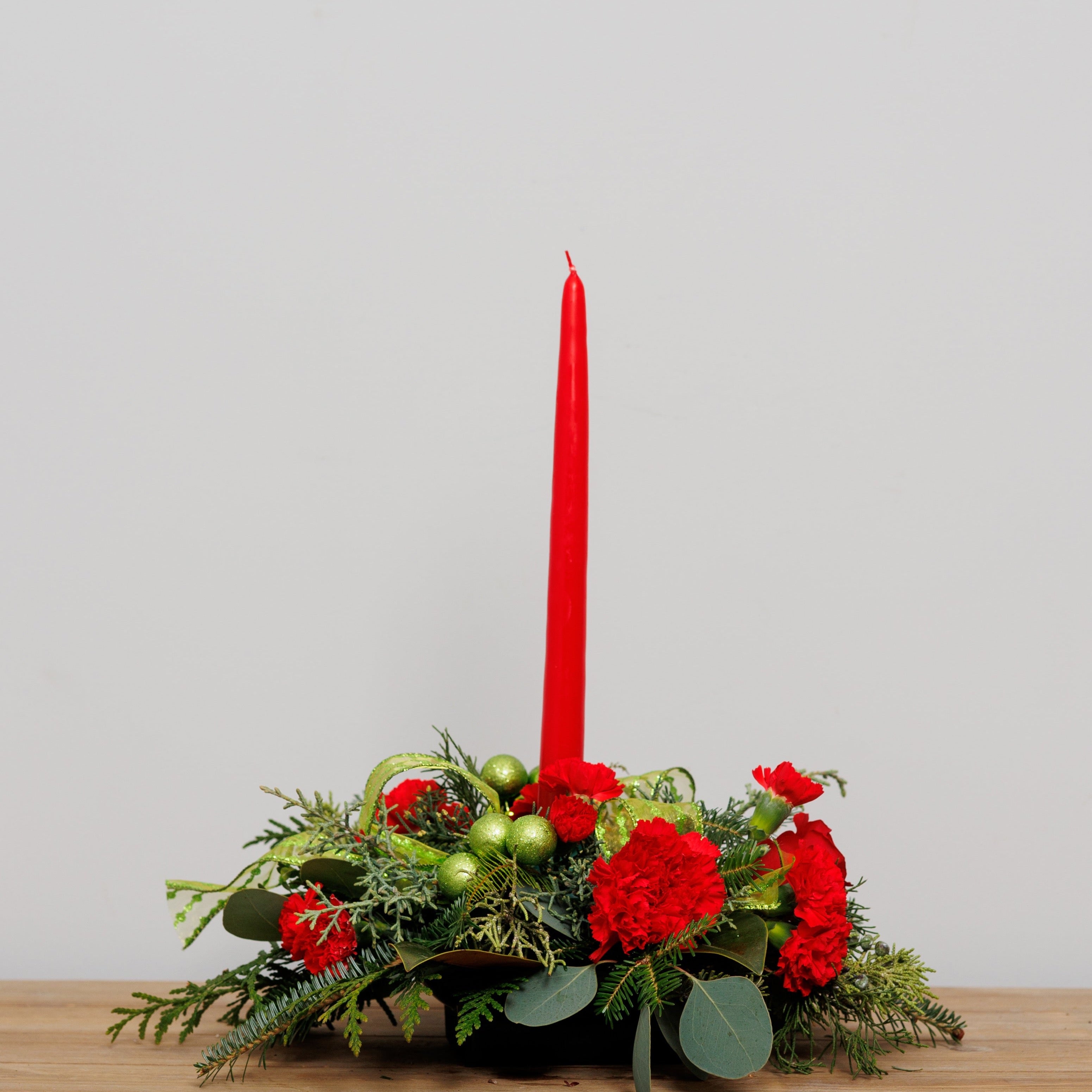 A red and lime green centerpiece with a single red candle.