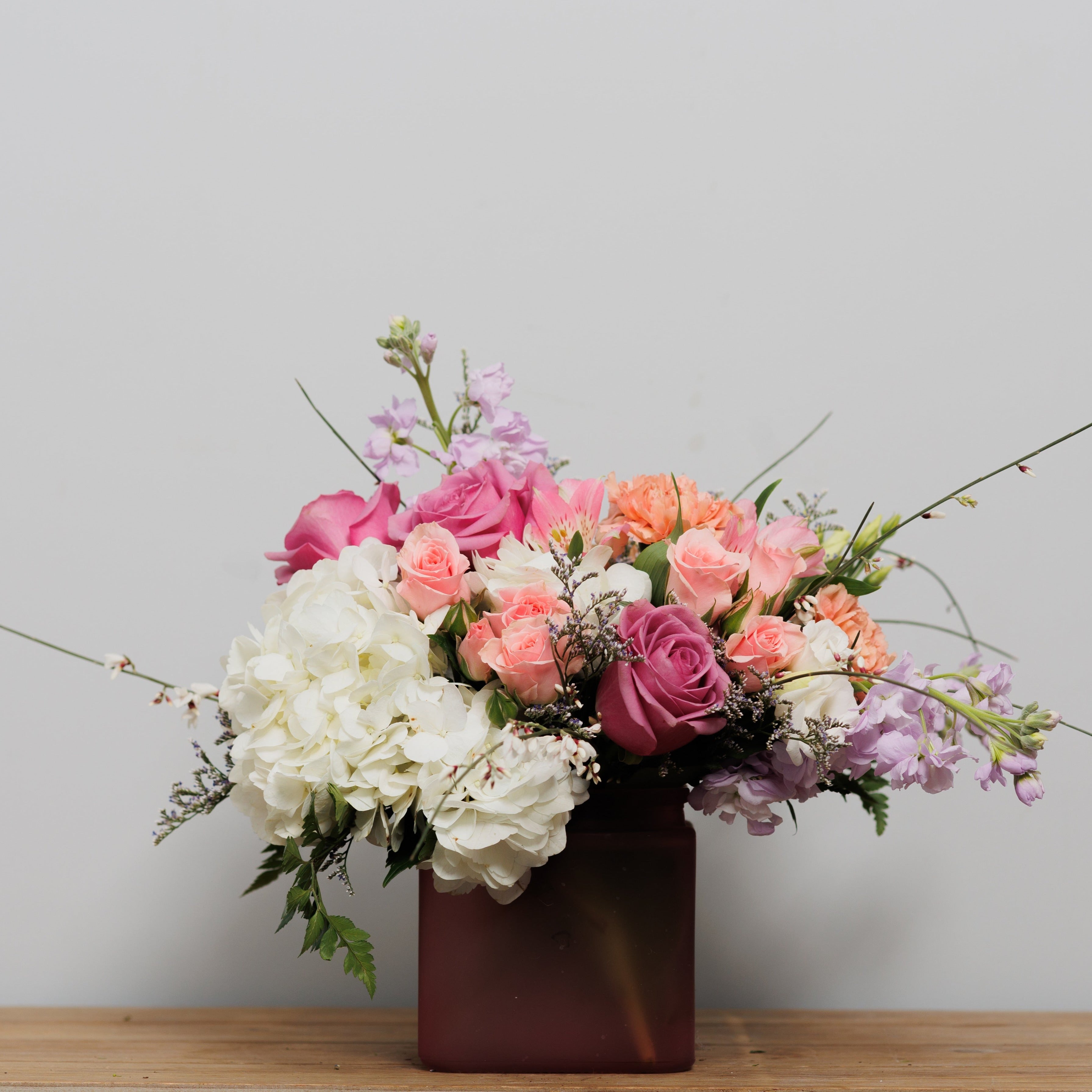 A cube arrangement with pink and white flowrers.