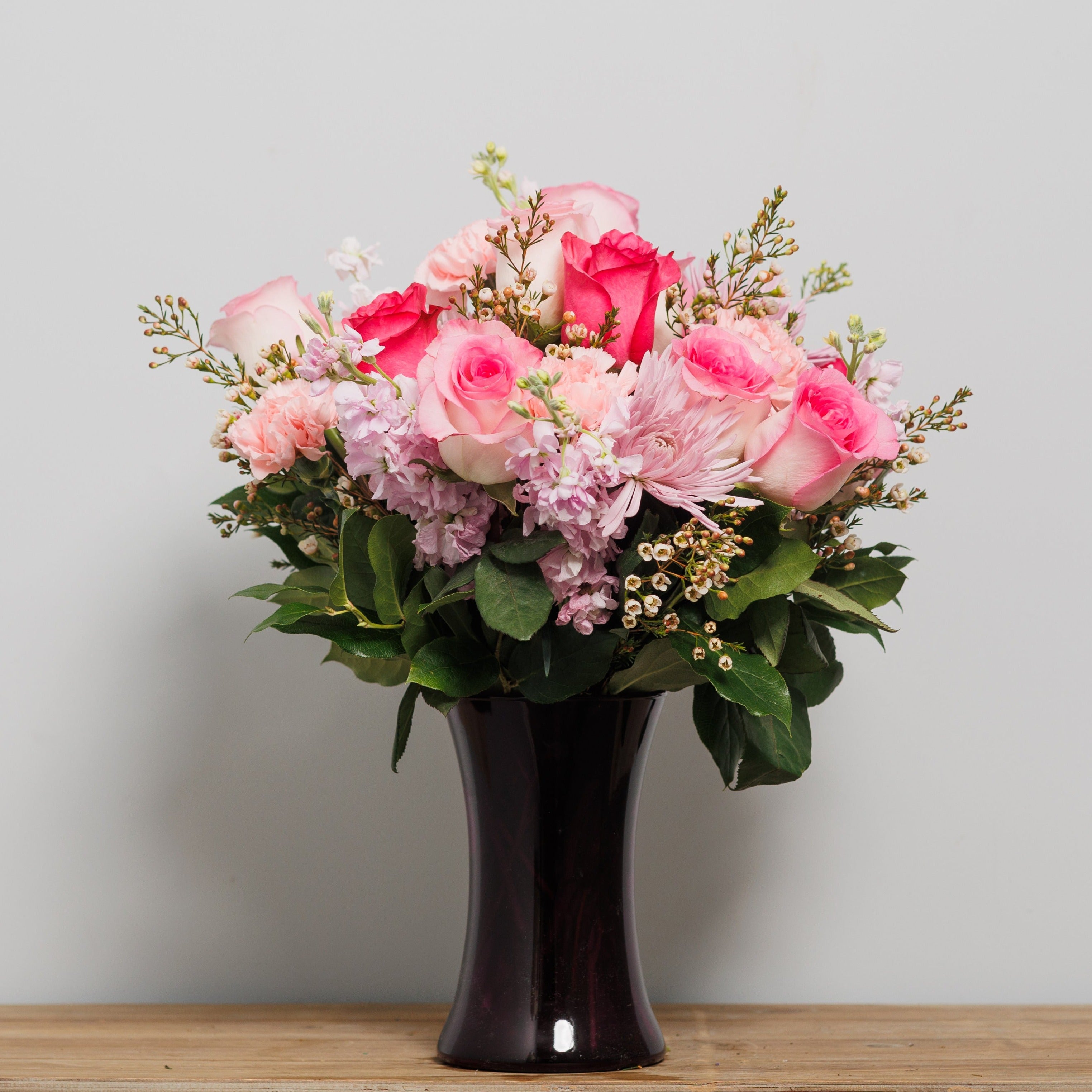A dozen pink roses with pink carnations and pink stock.