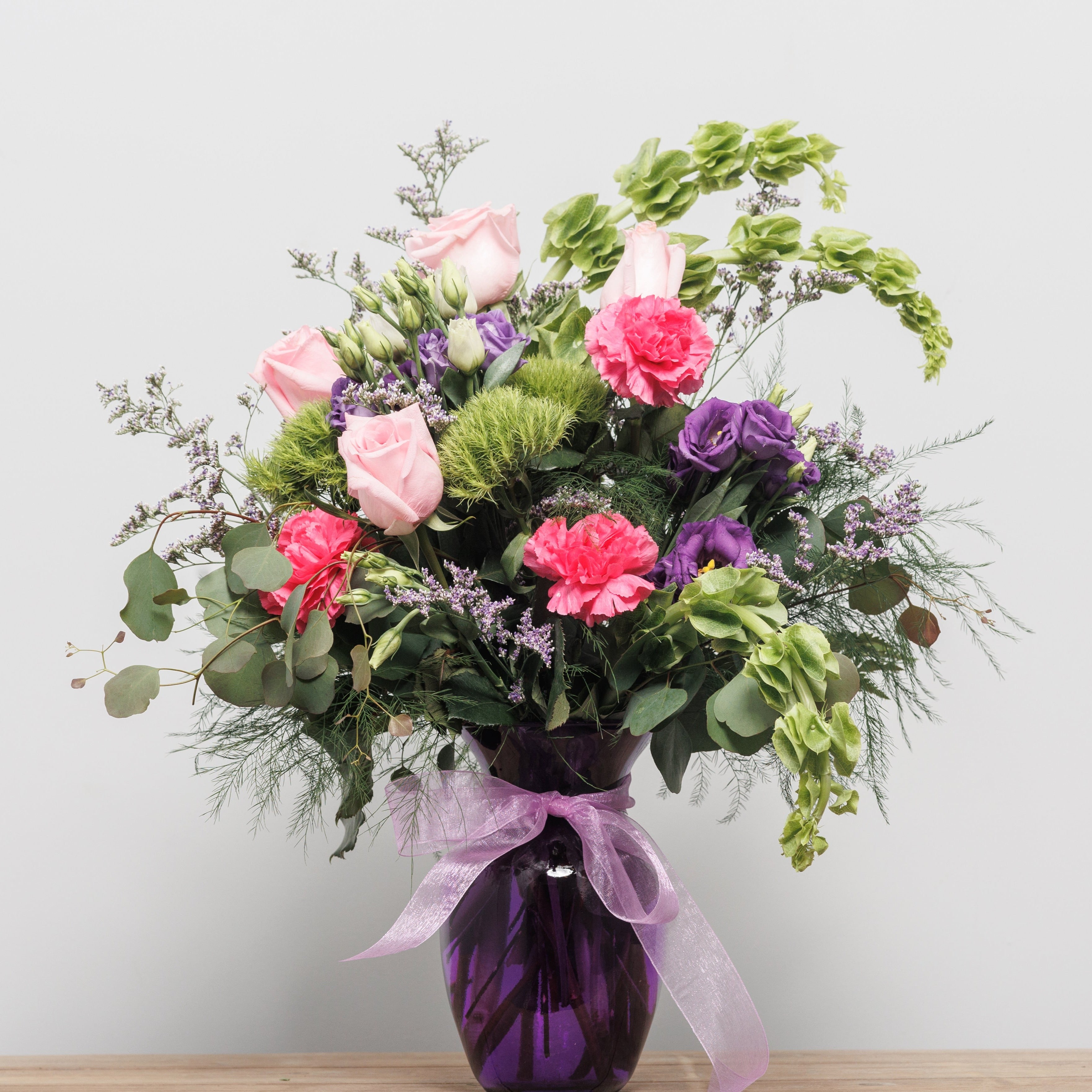 Lime green and pink flowers in a purple vase