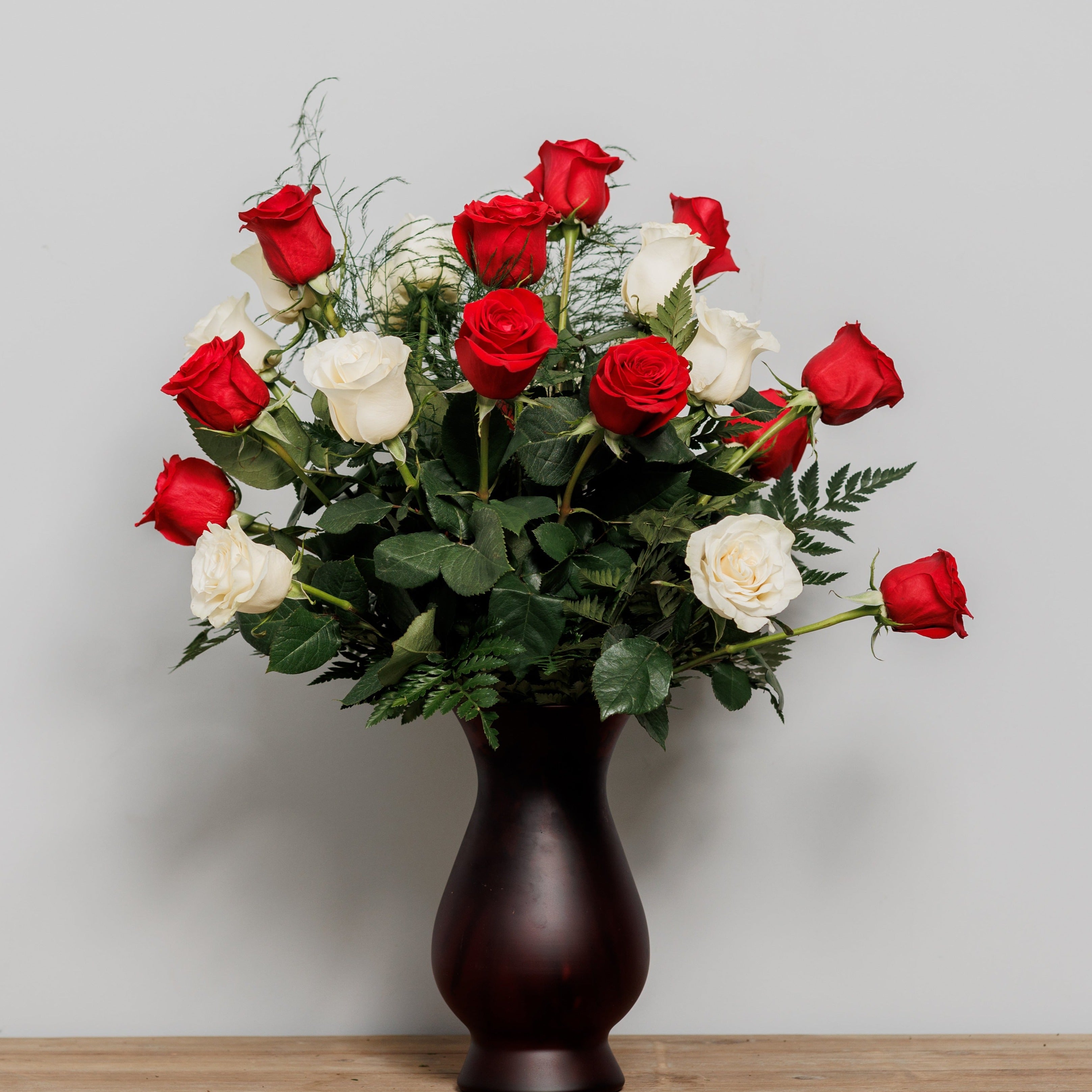Two dozen roses in a premium vase.