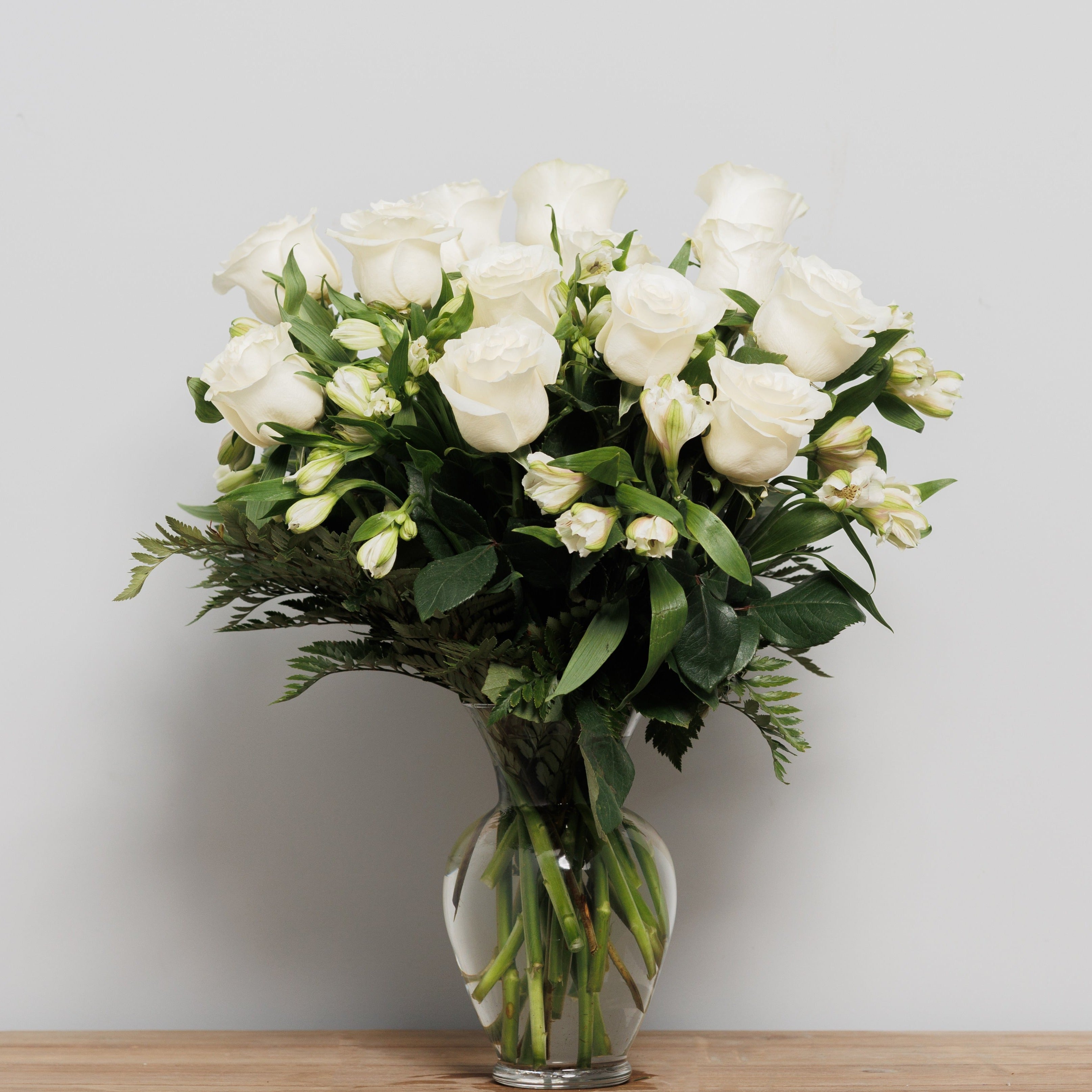 A vase arrangement with white roses and white alstroemeria.