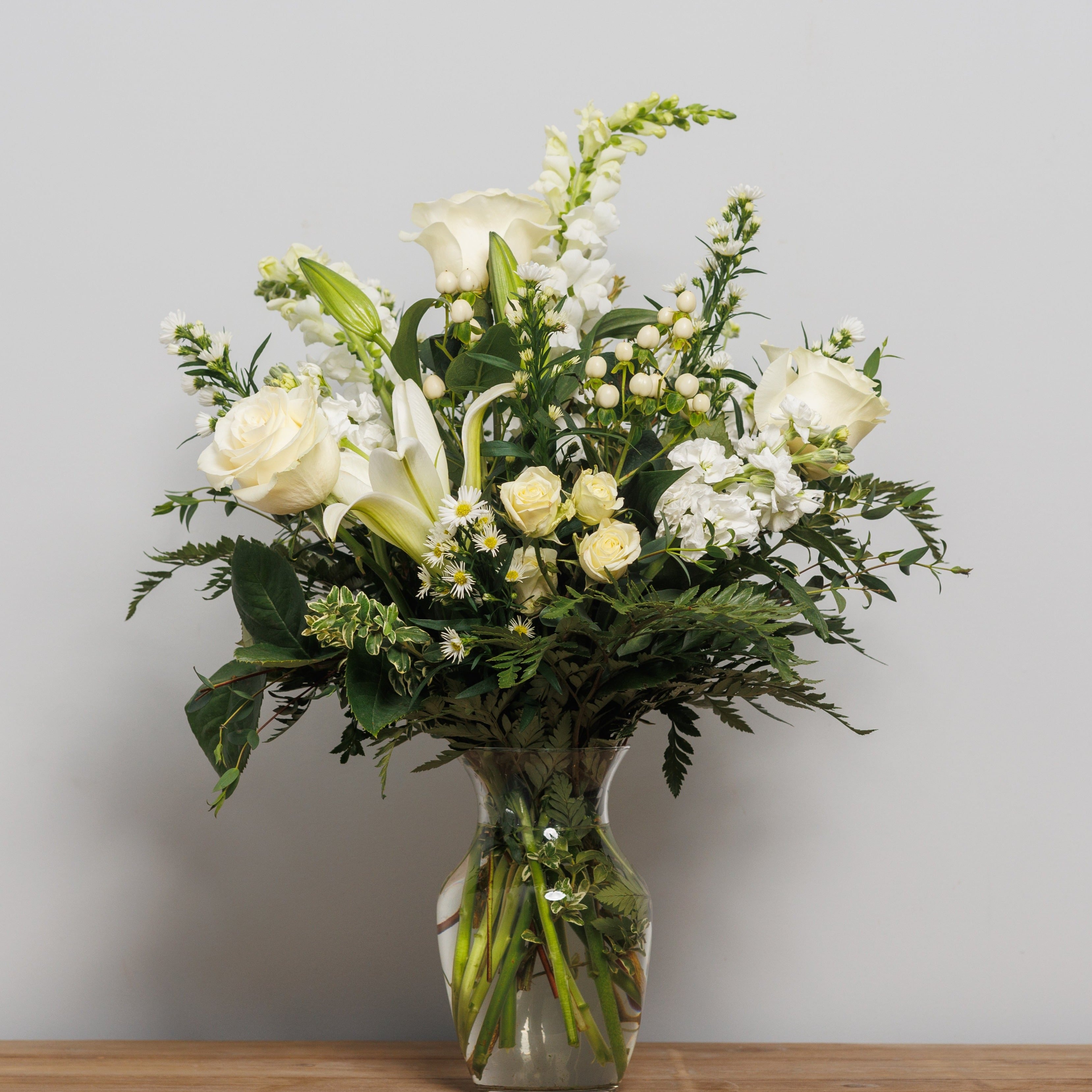 A vase arrangement with all cream colored flowers.