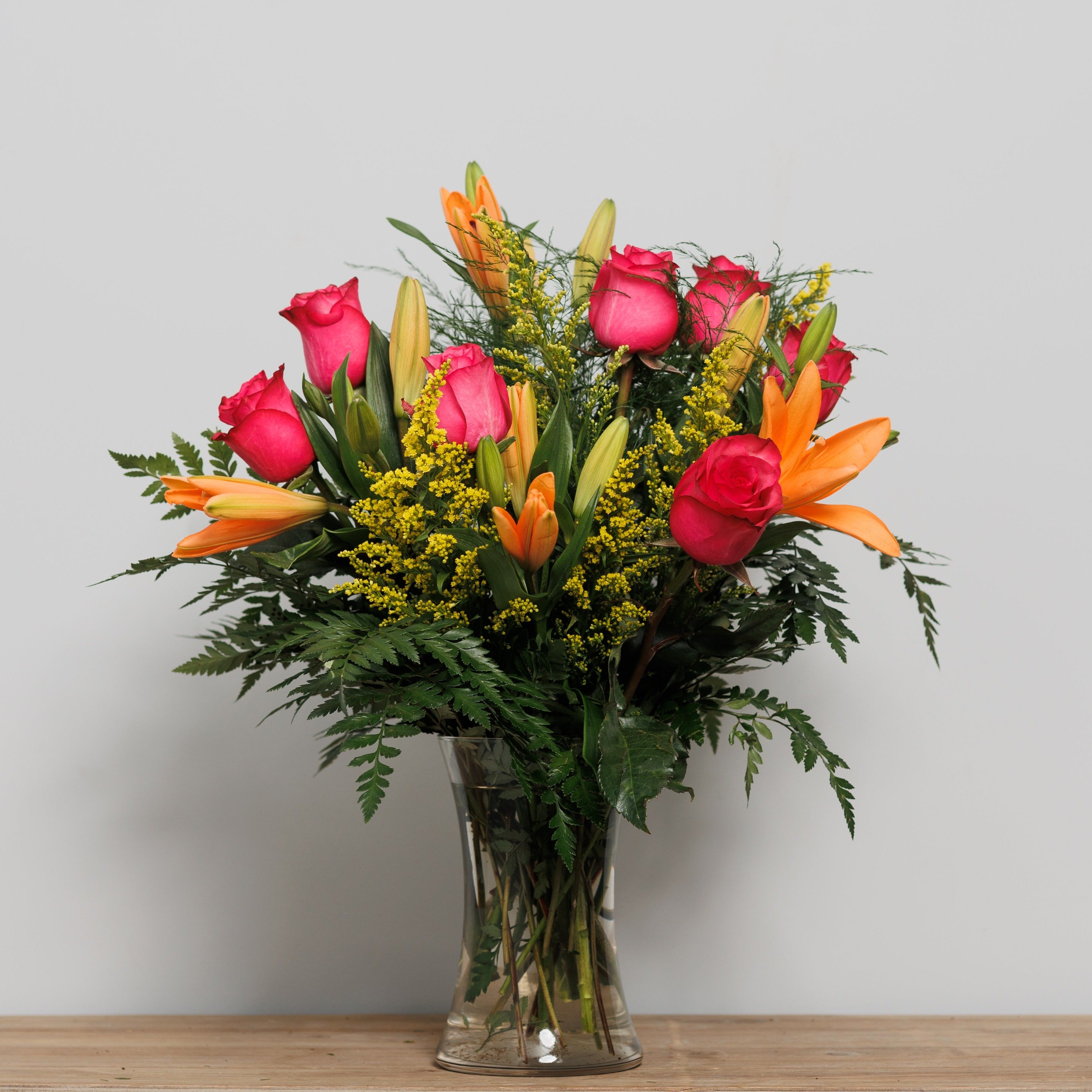 A vase arrangement with orange tiger lilies and hot pink roses.