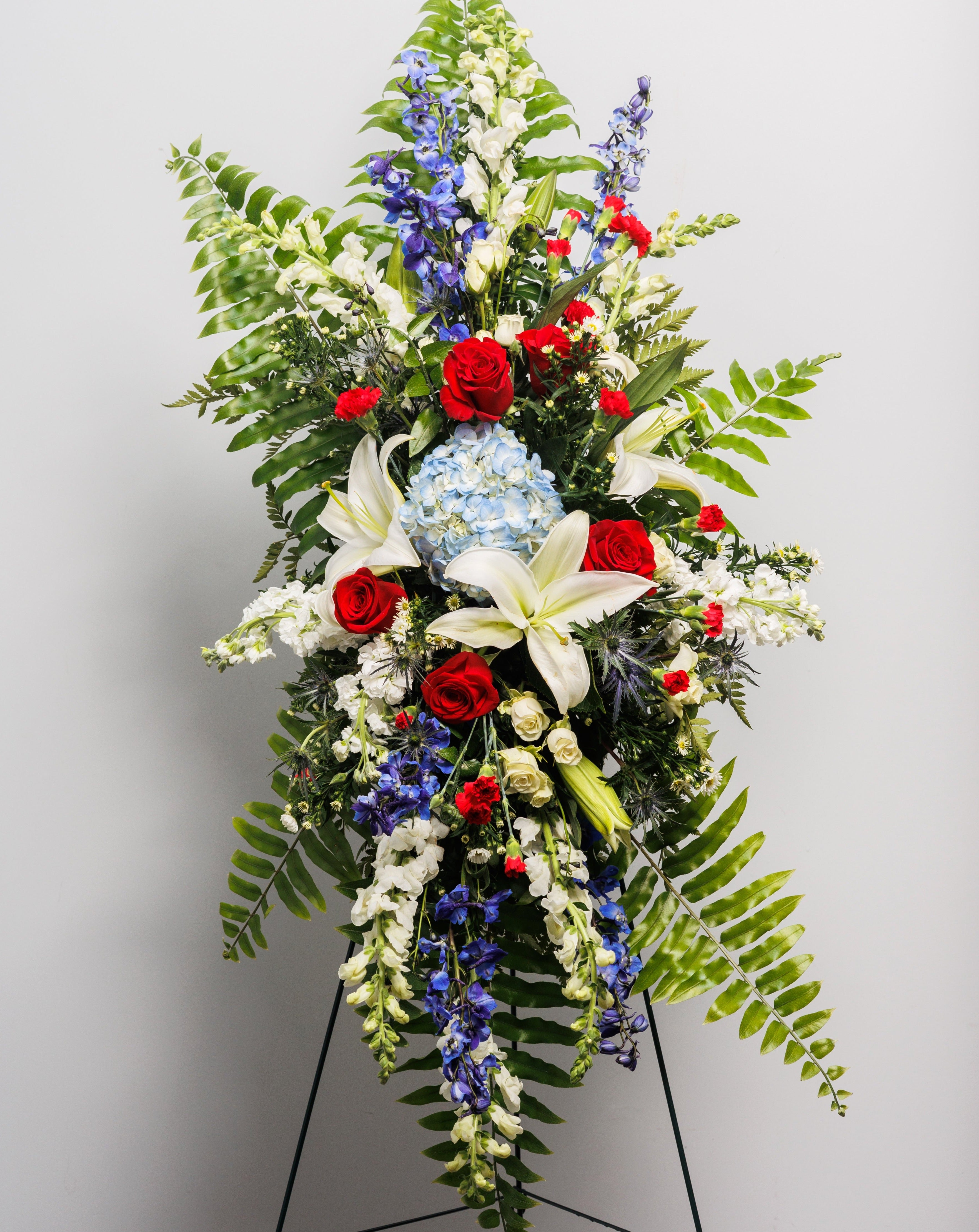 A patriotic standing spray with red, white and blue flowers.